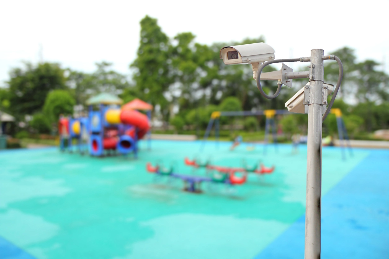 technician installing outdoor security camera near school playground