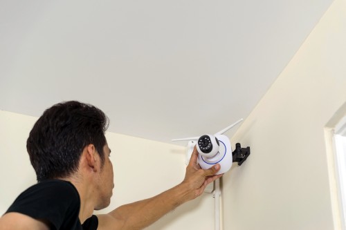 Man installing a residential security camera